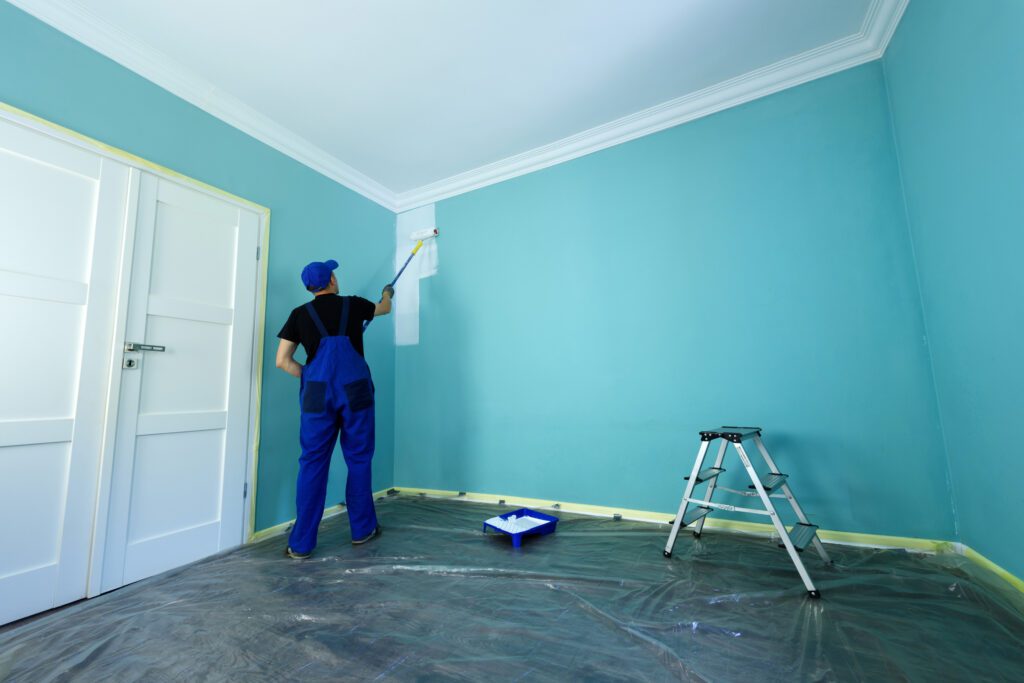 Professional painter preparing walls with drop sheets before painting