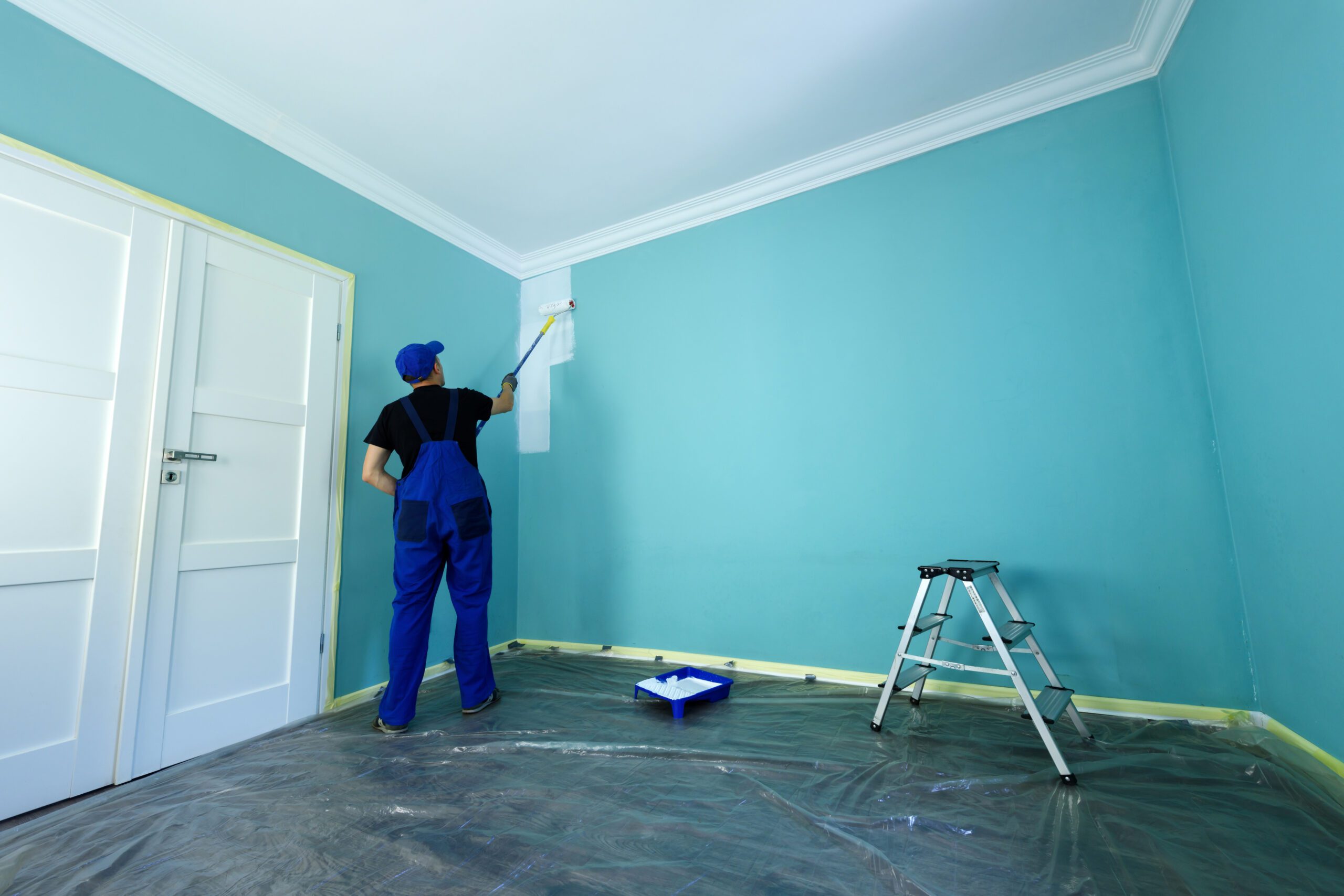 Professional painter preparing walls with drop sheets before painting