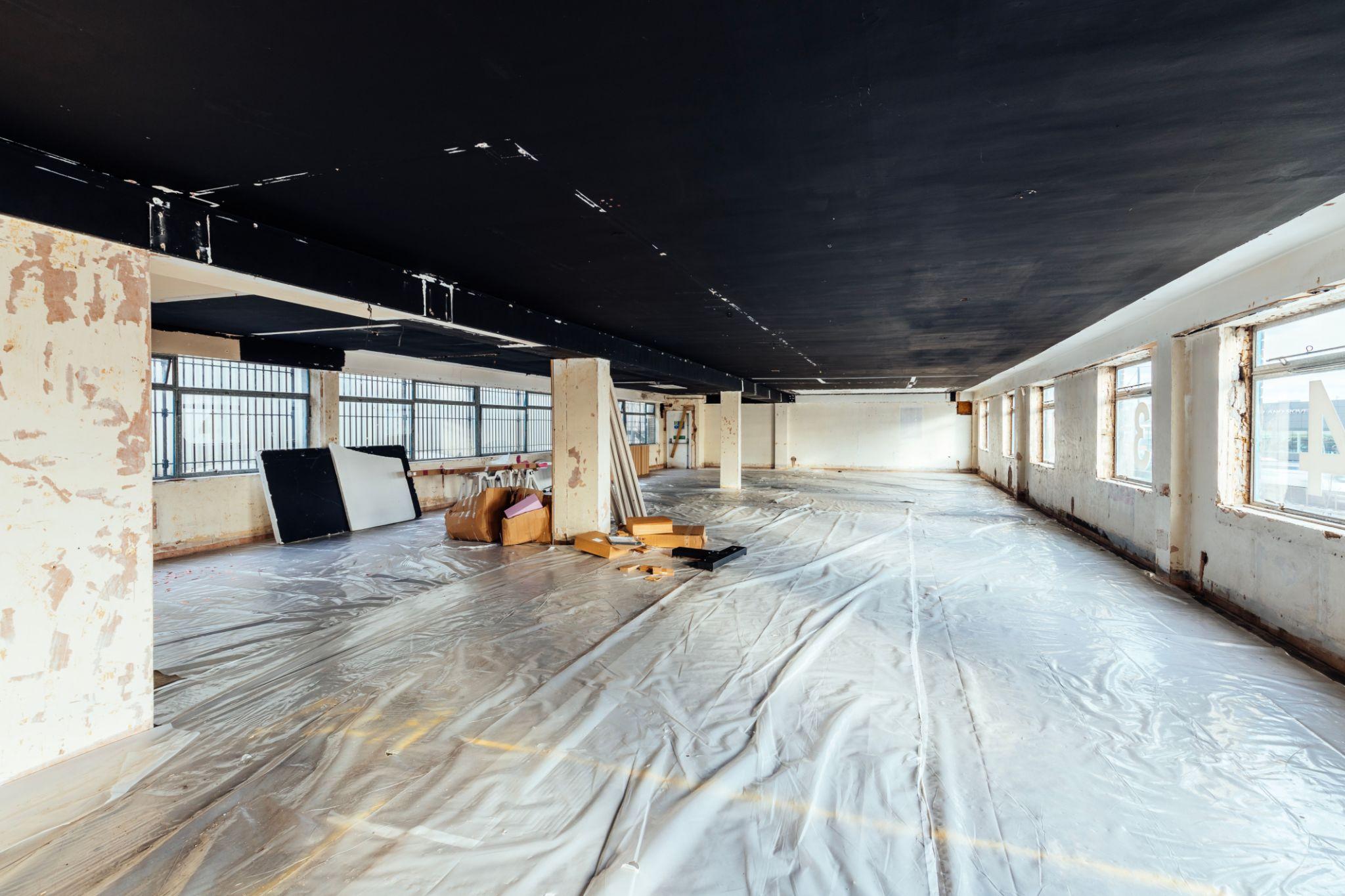 commercial workspace prepared for painting with covered furniture